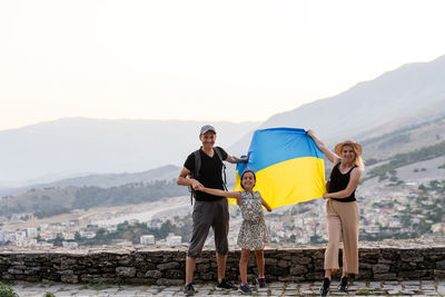Family with ukrainian flag in the mountains