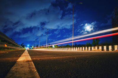 Light trails on road against sky at night