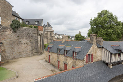 Buildings in town against cloudy sky