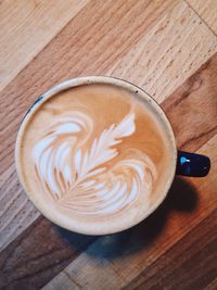 Directly above shot of coffee cup on wooden table