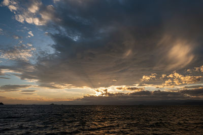 Scenic view of sea against dramatic sky during sunset