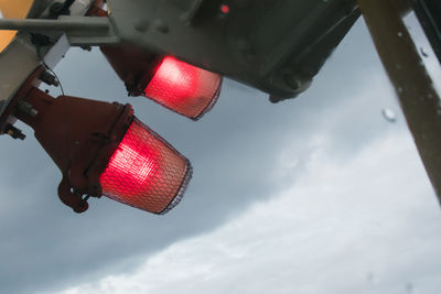 Low angle view of stoplight against sky