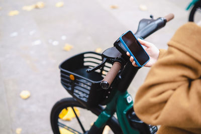 Woman using smart phone to rent electric bicycle