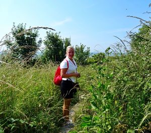 Portrait of woman standing on field against sky