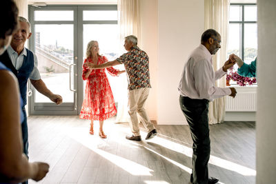 Multiracial senior couples practicing dance in class