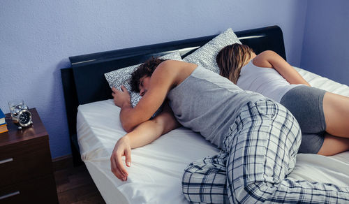Midsection of woman relaxing on bed at home