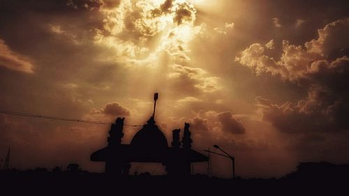 Low angle view of silhouette statue against sky at sunset