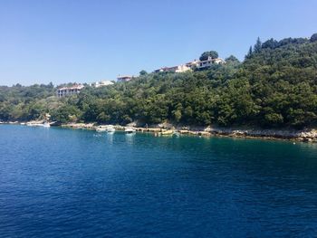 Scenic view of lake against clear blue sky