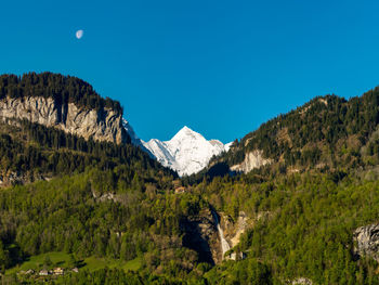 Scenic view of mountains against clear blue sky