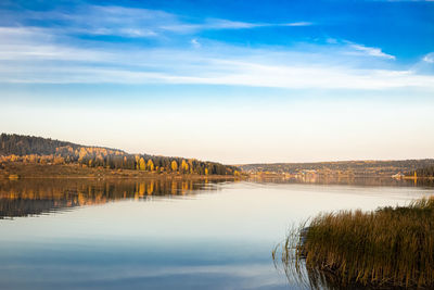 Scenic view of lake by trees against sky