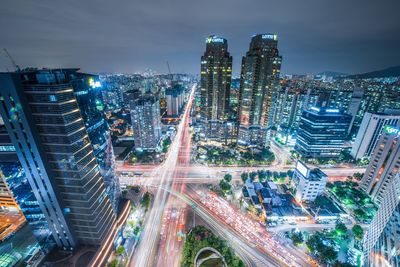 High angle view of illuminated city street and buildings at night