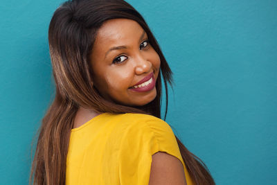 Portrait of smiling woman against blue background