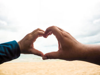 Midsection of man with hands against sky