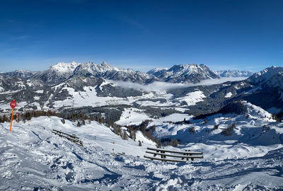 Scenic view of snow covered mountains in the austrian alps against blue sky