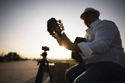 Guitarist playing guitar at sunset