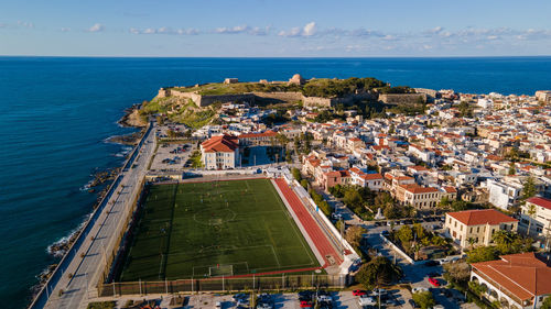 High angle view of buildings by sea against sky