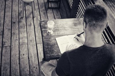 Midsection of man sitting on table at home