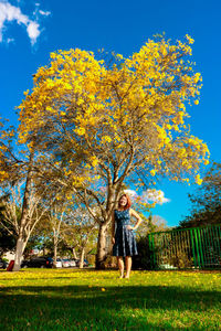 Full length of smiling boy against blue sky