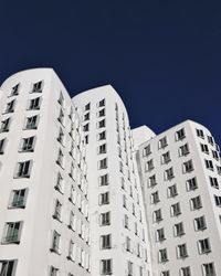 Low angle view of buildings against clear blue sky