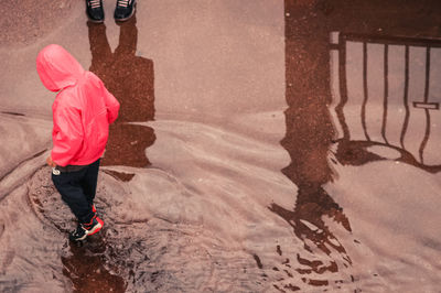 High angle view of boy walking in water outdoors