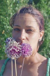 Close-up portrait of woman holding flower outdoors
