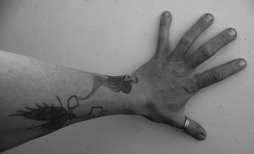 Cropped hand of man touching wall