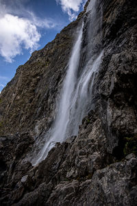 Low angle view of waterfall against sky