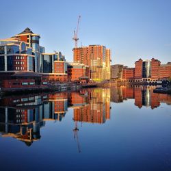 Reflection of buildings in city against sky