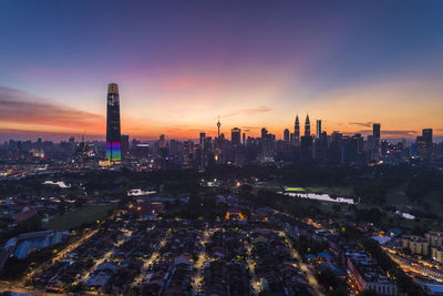 Aerial view of buildings in city against sky during sunset