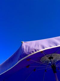 Low angle view of flags against clear blue sky