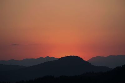 Scenic view of silhouette mountains against romantic sky at sunset