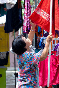 Woman holding textile hanging for drying outdoors