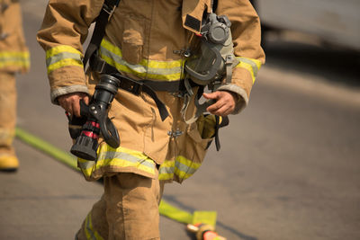 Midsection of firefighter on street