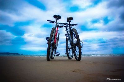 Bicycle on beach against sky