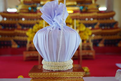 Close-up of buddha statue on table against building