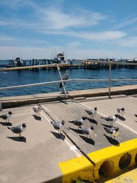 Boats moored on pier by sea against sky