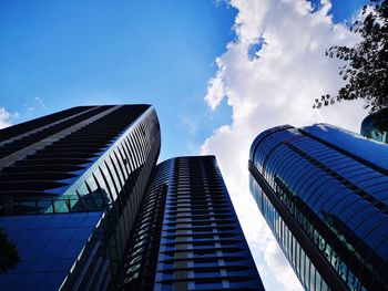 Low angle view of modern buildings against blue sky