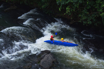 People surfing on rock in river