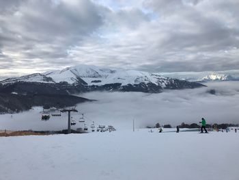 Scenic view of snowcapped mountains against cloudy sky