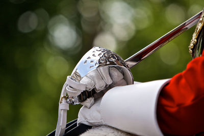 Cropped hands of man holding sword outdoors