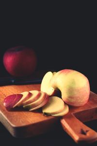 Close-up of apple on table against black background