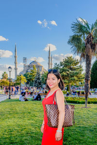 Portrait of smiling woman standing in city