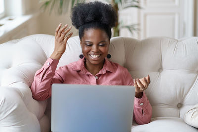 Young woman talking on video call while sitting at home