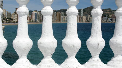 View of sea against city seen through baluster