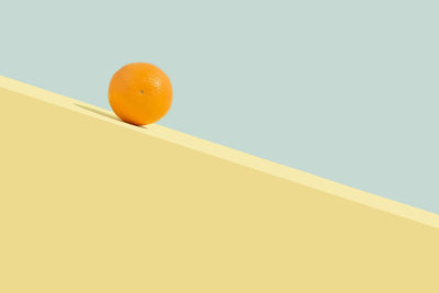 Low angle view of orange slice against yellow background