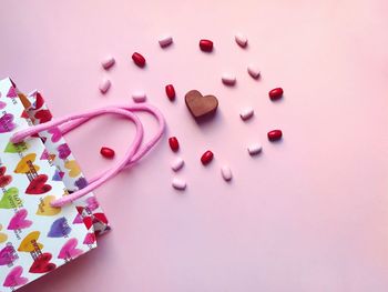 High angle view of heart shape over pink background