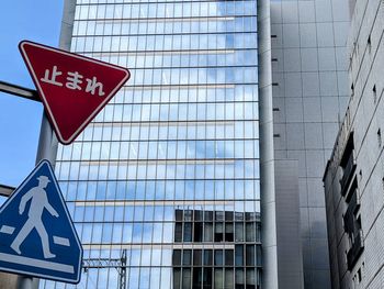 Low angle view of road sign against building