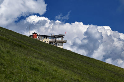 Low angle view of traditional windmill on field against sky