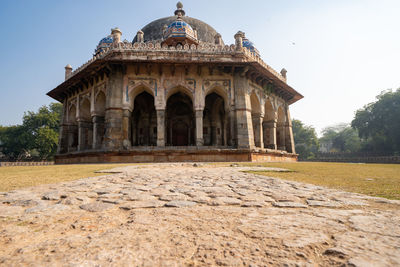 Facade of old temple building against clear sky