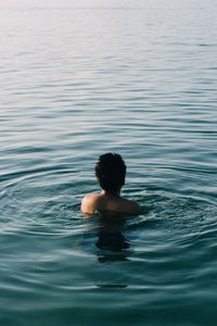 Rear view of shirtless boy in swimming pool